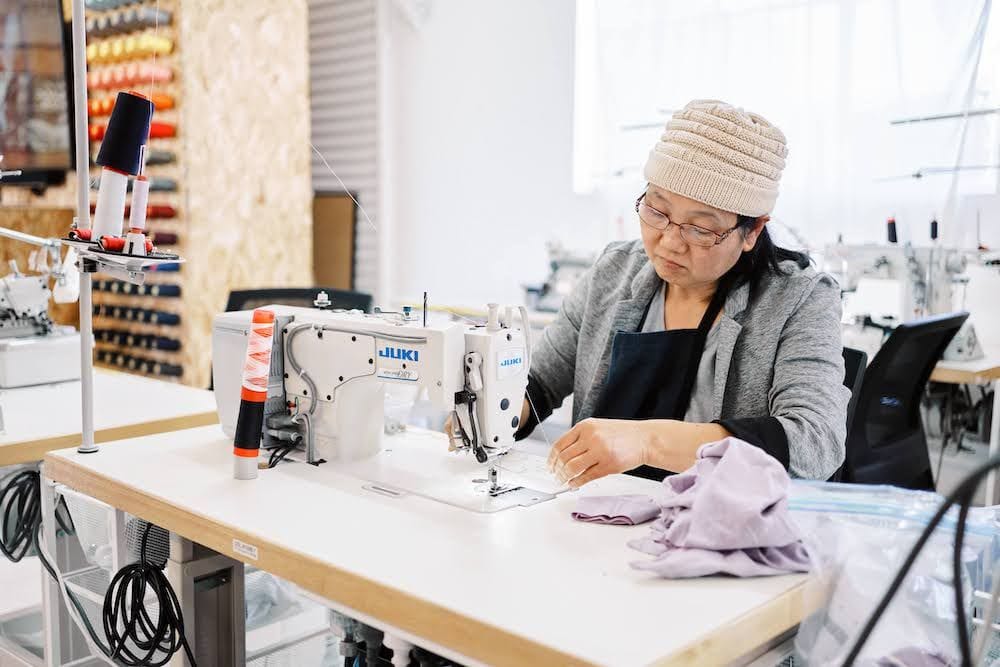 Seamstress prepares sowing machine to make Citizen Wolf T-shirt (Provided)