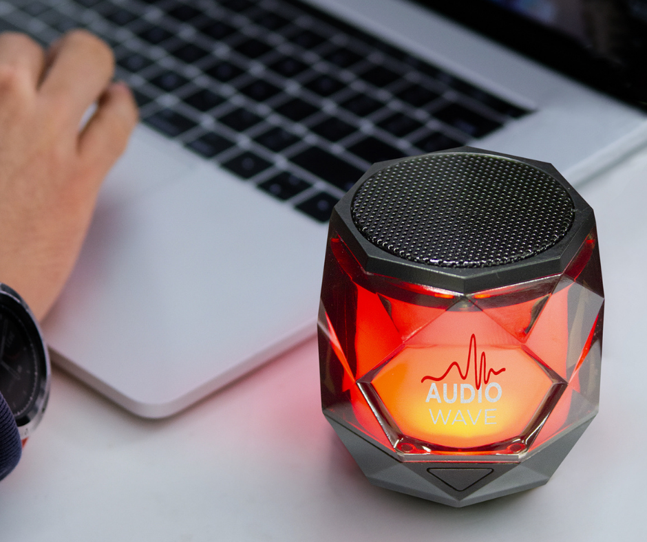 Promotional bluetooth speaker on desk with computer