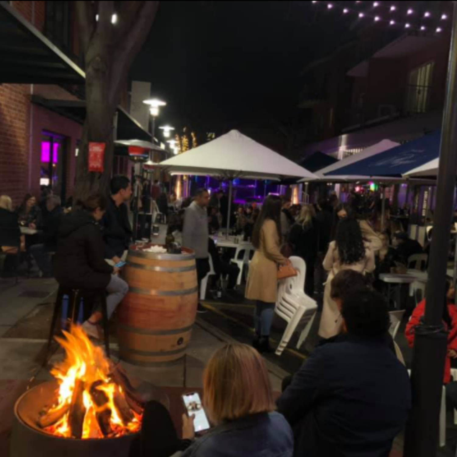 Outdoor event setup featuring Tick Party Hire Wine barrels