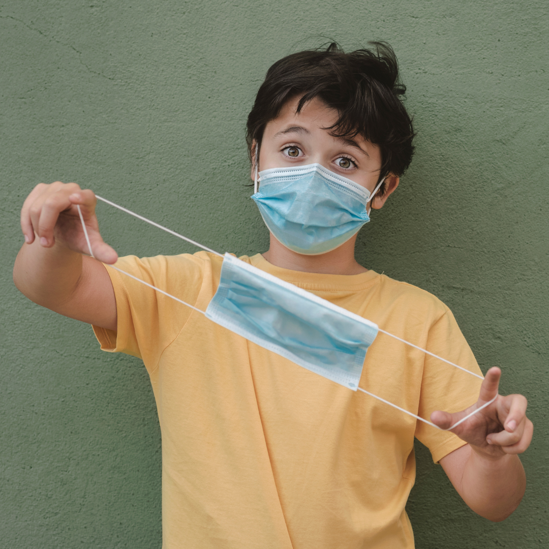 Child wearing and holding kids size disposable facemask