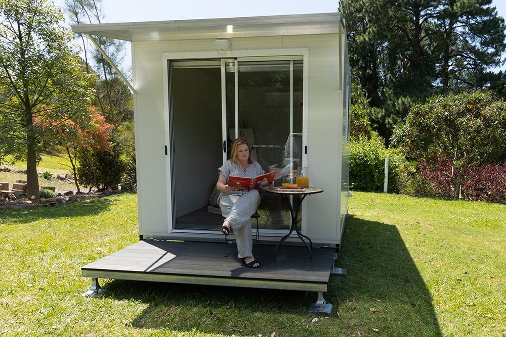 Lady sitting on deck in front of portable granny flat