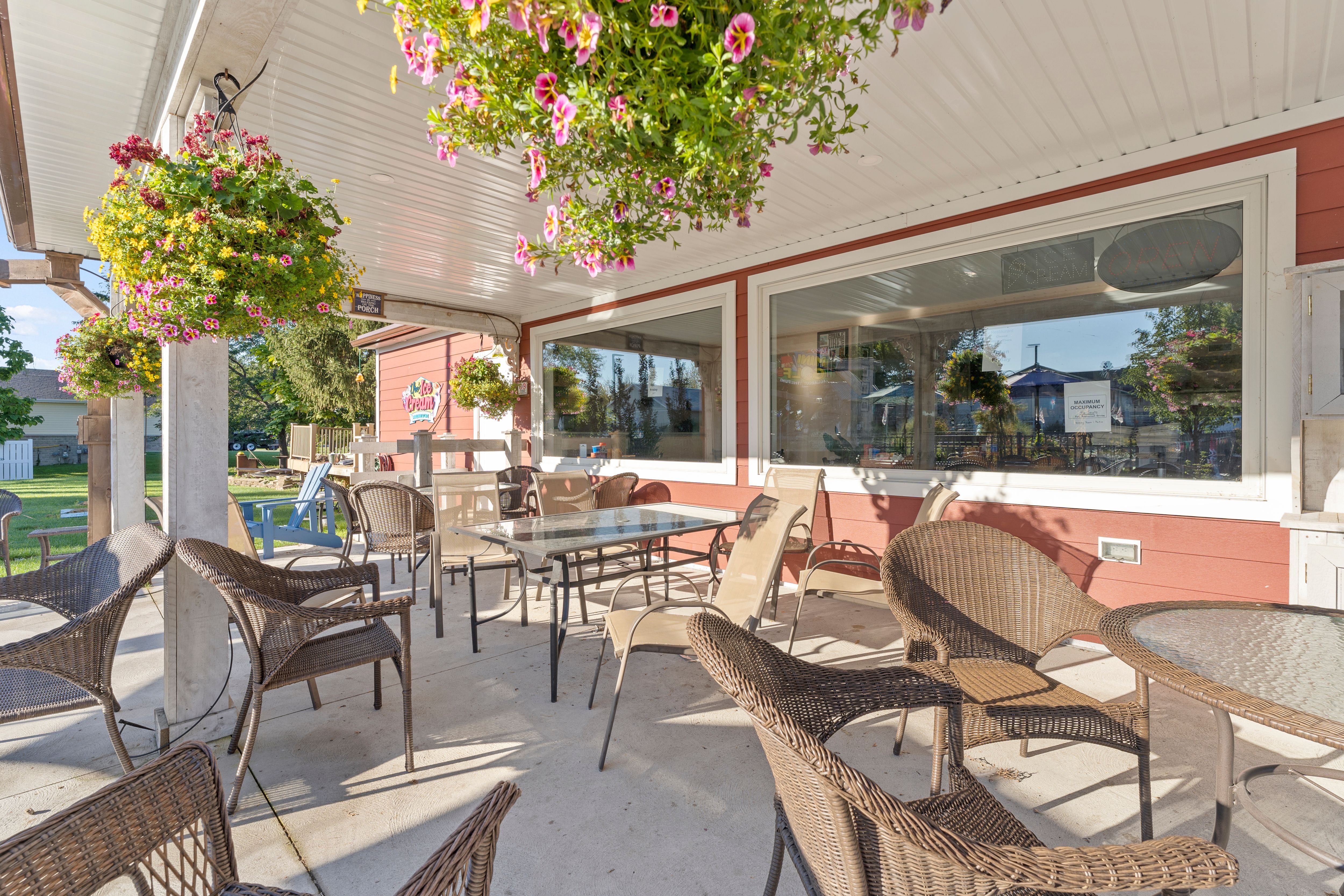 Looking onto the patio between Ure's Country Kitchen, the restaurant and Ure's Mini Golf Course, featuring lots of seating, a clean environment and flower baskets hanging down from the roof