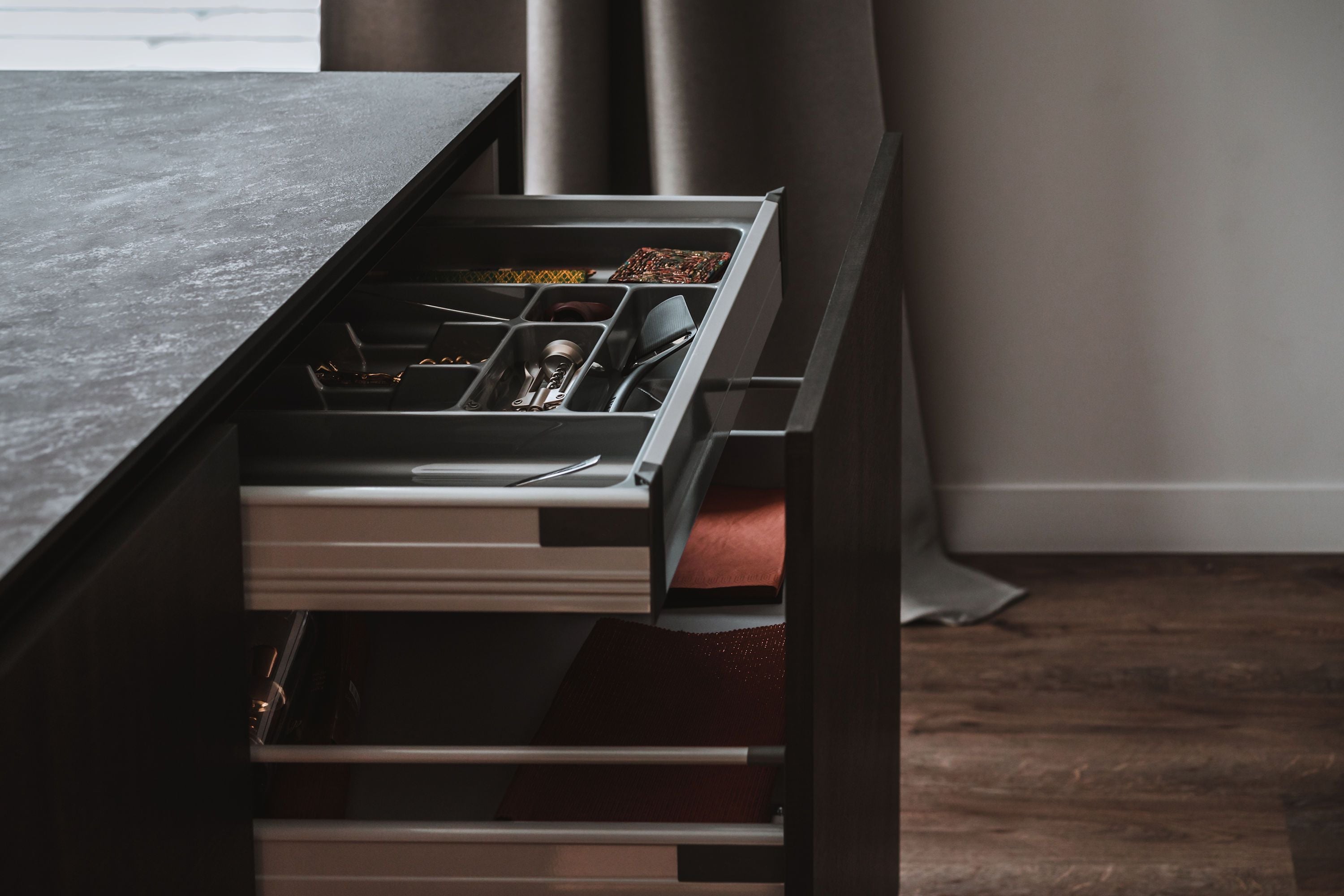 Custom cabinets designed to include hidden drawers, including a deep drawer to large pots and pans, and a more shallow drawer for utensils and smaller cooking tools