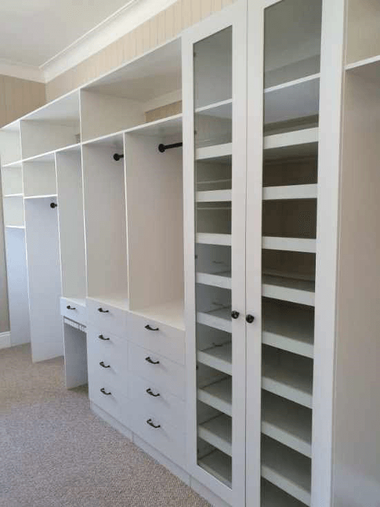 Galley style WIR using white HMR Melamine. Closed drawers with black handle, black hanging rods & Artia trouser rack & slide out shoe shelves. Hinged doors with 6mm toughened clear glass inserts