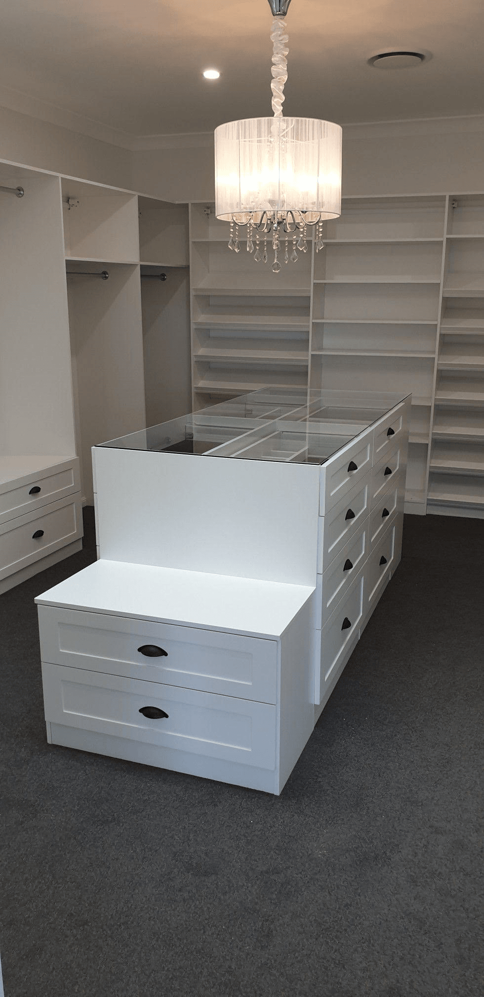 White WIR with shaker profile drawer fronts. Centre Island with seat & glass top. Sloping shoe racks with upstands and slide out scarf cupboard