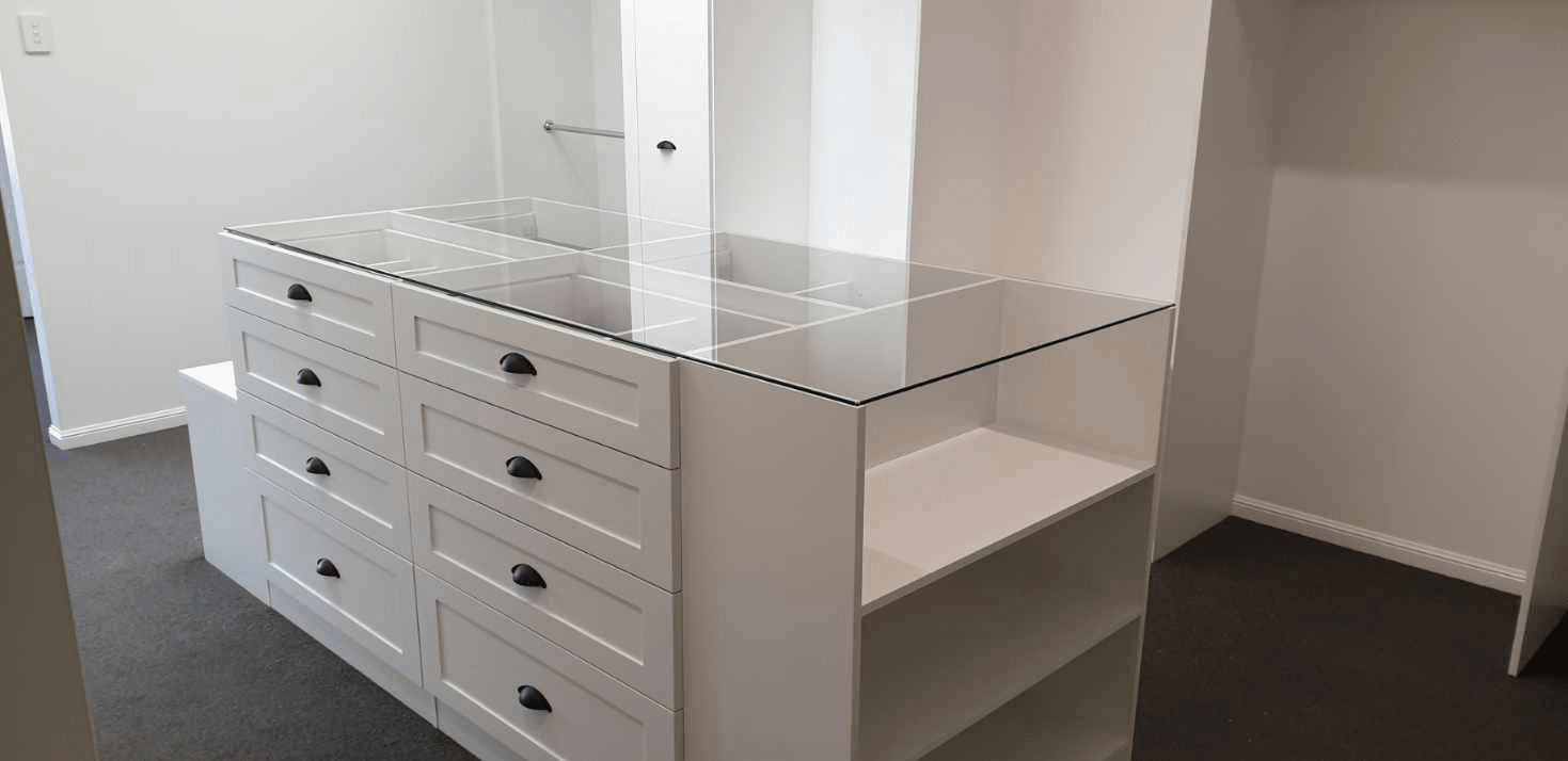 White WIR with shaker profile drawer fronts. Centre Island with seat & glass top. Sloping shoe racks with upstands and slide out scarf cupboard