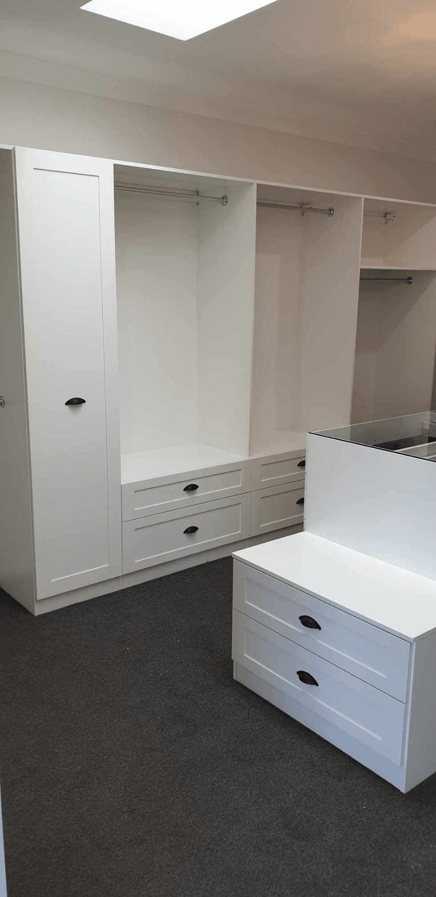 White WIR with shaker profile drawer fronts. Centre Island with seat & glass top. Sloping shoe racks with upstands and slide out scarf cupboard