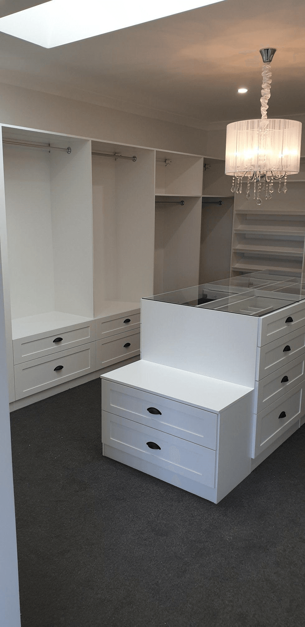 White WIR with shaker profile drawer fronts. Centre Island with seat. Sloping shoe racks with upstands and slide out scarf cupboard