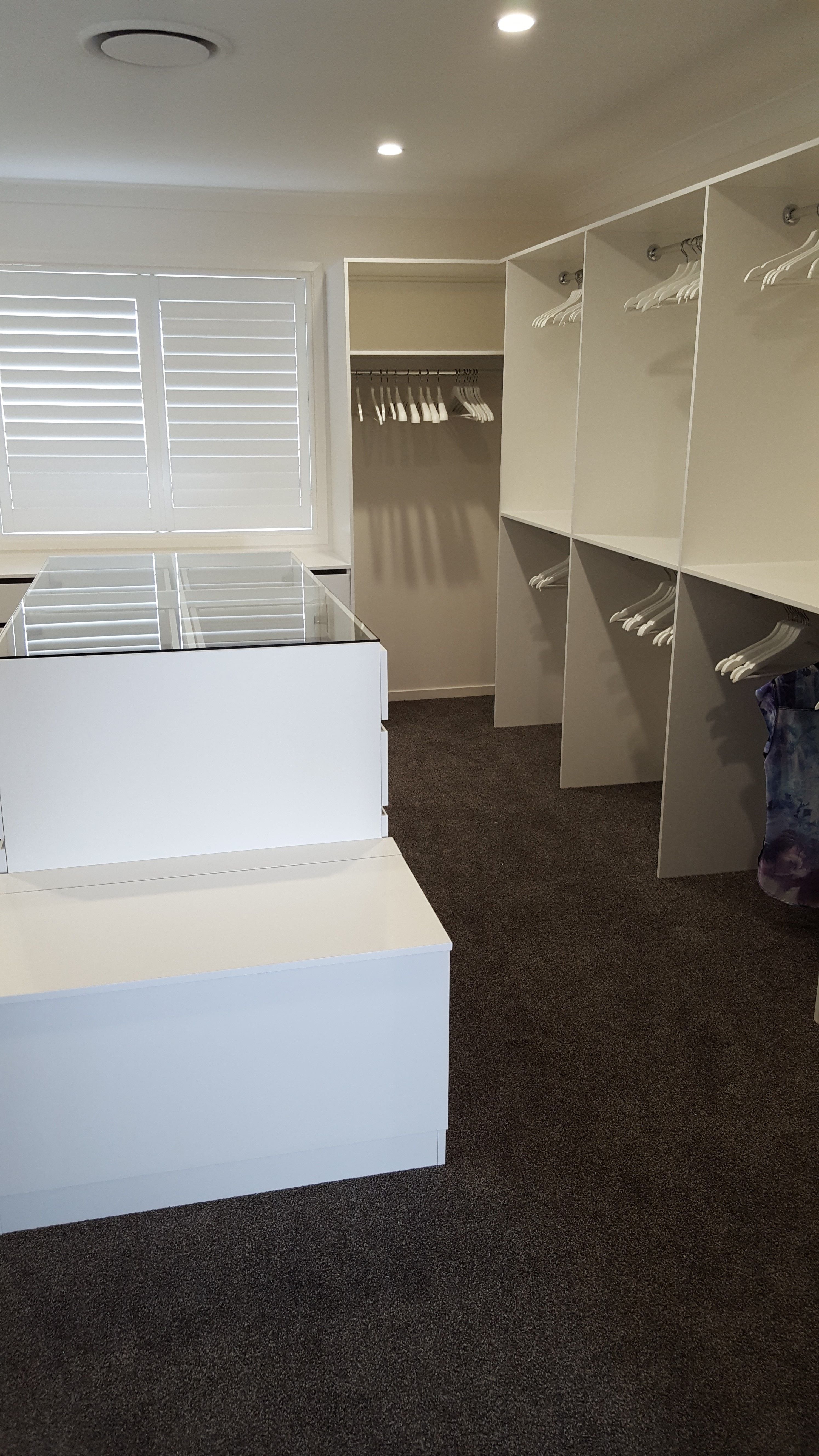 WIR using White HMR Melamine, centre island with 6mm toughened clear glass top. Blanket box seat. No backing. Open drawer fronts and white 32mm diameter hanging rail