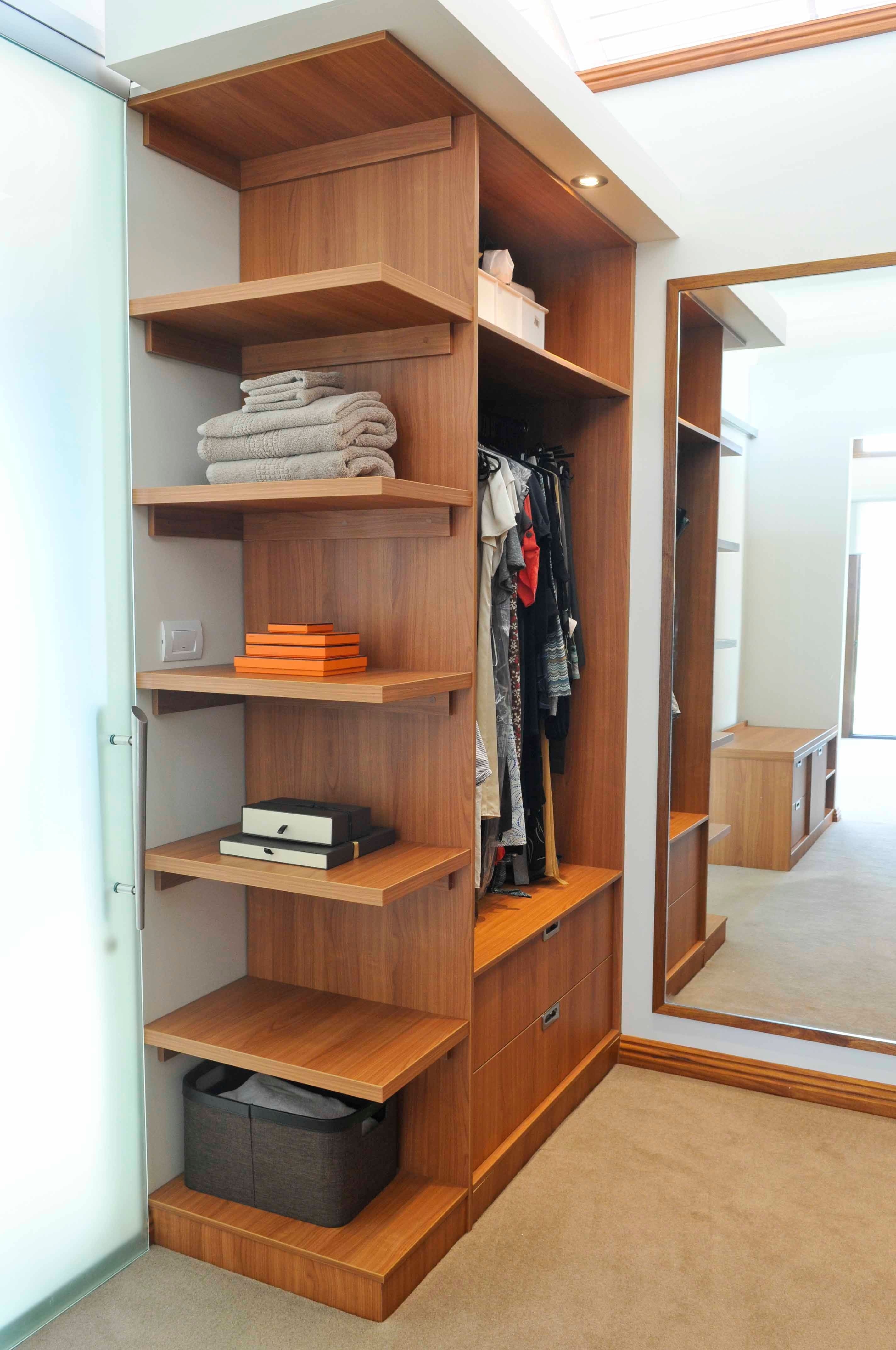 Walk in robe using Laminex Country Cherry. Floating shelves. Overhanging bulkhead with downlights. Wall mirror with border. Recessed handle drawers