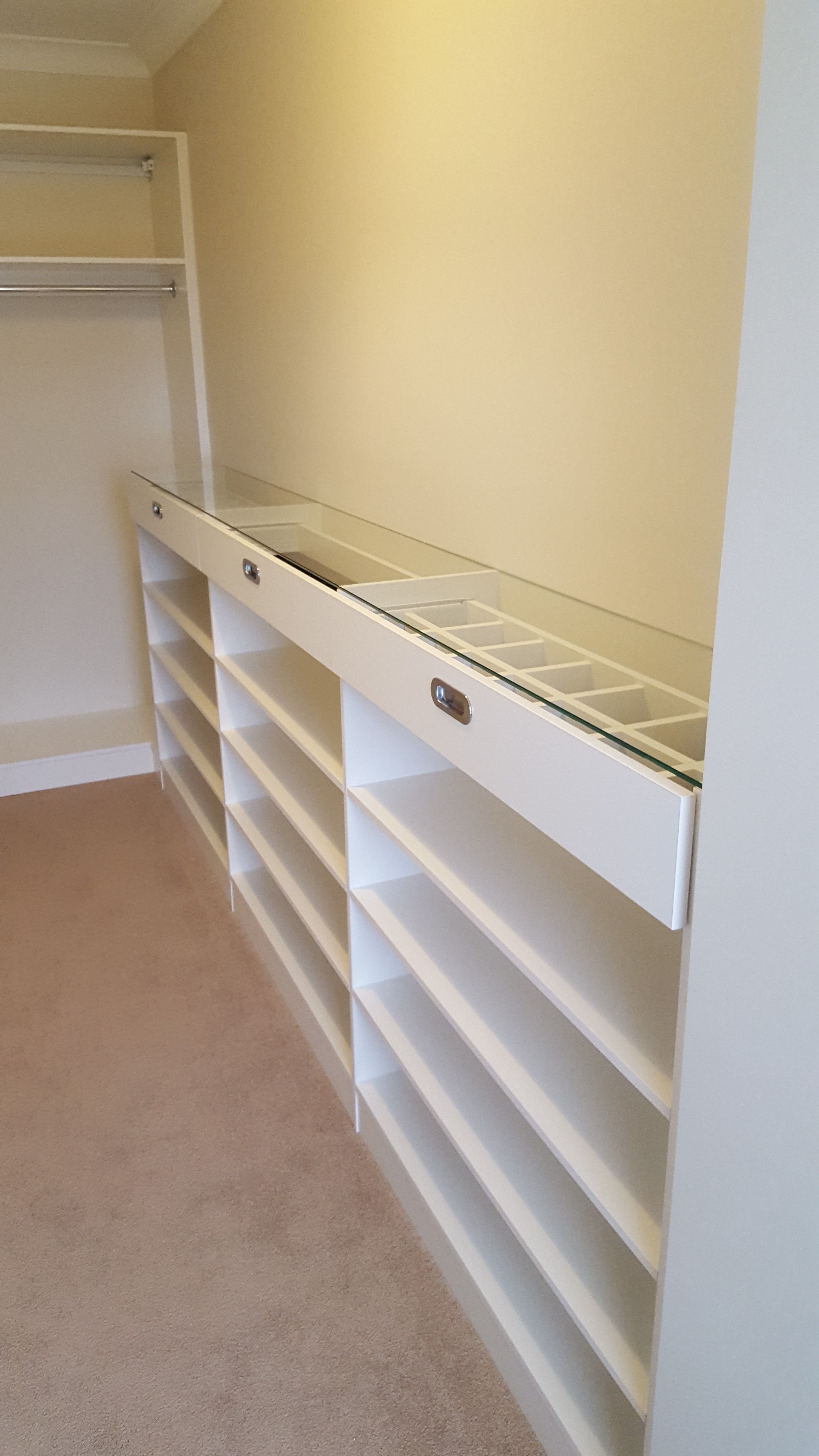 White WIR. Drawer fronts with recessed handle. 6mm toughened clear glass top. Top drawers with dividers. Flat shoe shelving
