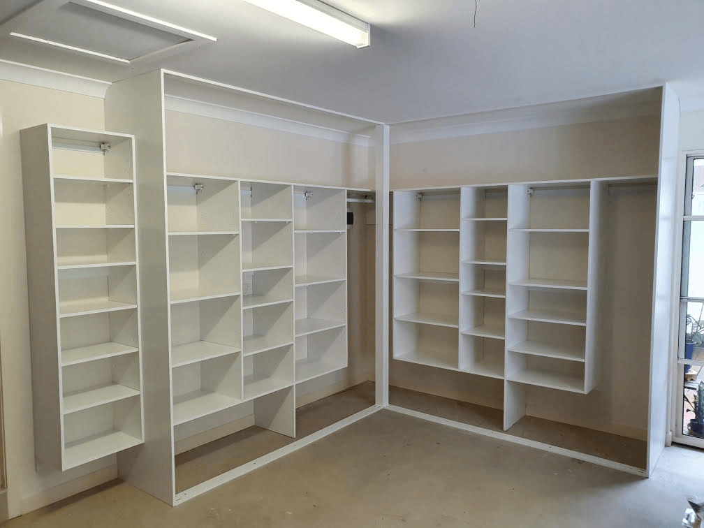 Garage storage using 16mm White HMR Melamine. All suspended 400mm off the floor. Support post for sliding doors to close against. External shoe shelving