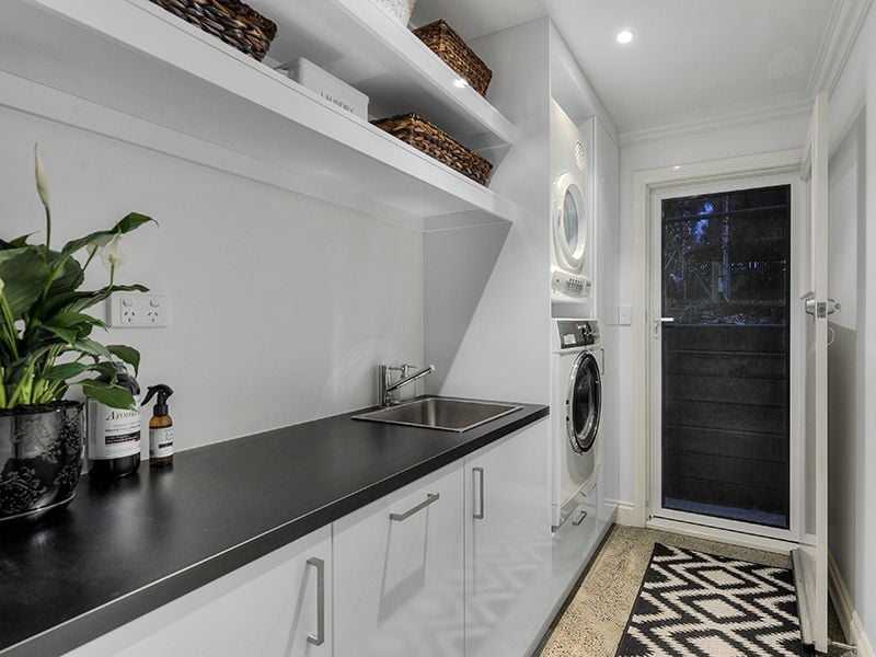 Laundry fit out using Polytec "Polar White sheen" and 33mm black matt post form bench top
