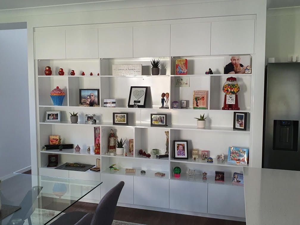 Display shelving using Polytec "Polar White sheen". Overhead head and underneath hinged doors with Blum push catch openers.