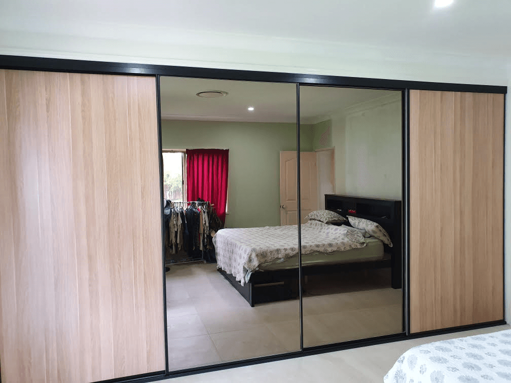 1 set of 4 fully framed sliding doors. 2 x Polytec "Natural Oak Matt" panels & 2 x 4mm vinyl backed dark grey mirror panels. Dias black trims & tracks
