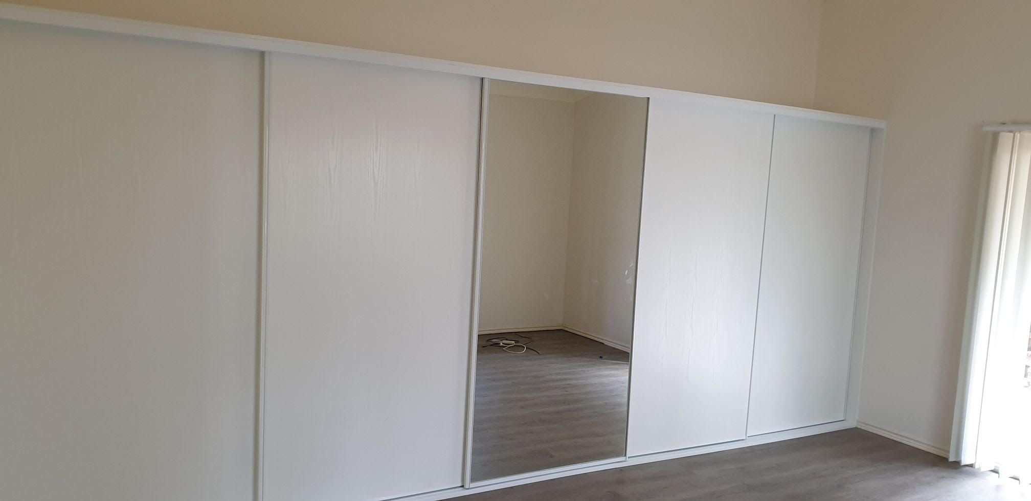 1 set of 5 fully framed sliding doors . 4 x "Glacier" vinyl panels & 1 x silver mirror panel. Dais White aluminum trims & tracks