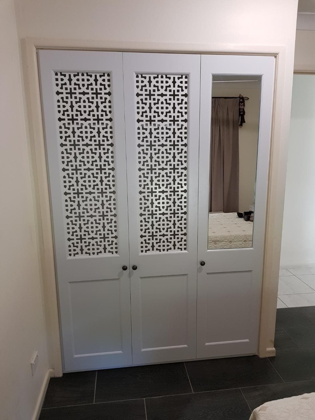 Hinged doors with 2 pack painted finish. Profile bottom panel and powder coated decorative screen inserts and single mirror insert