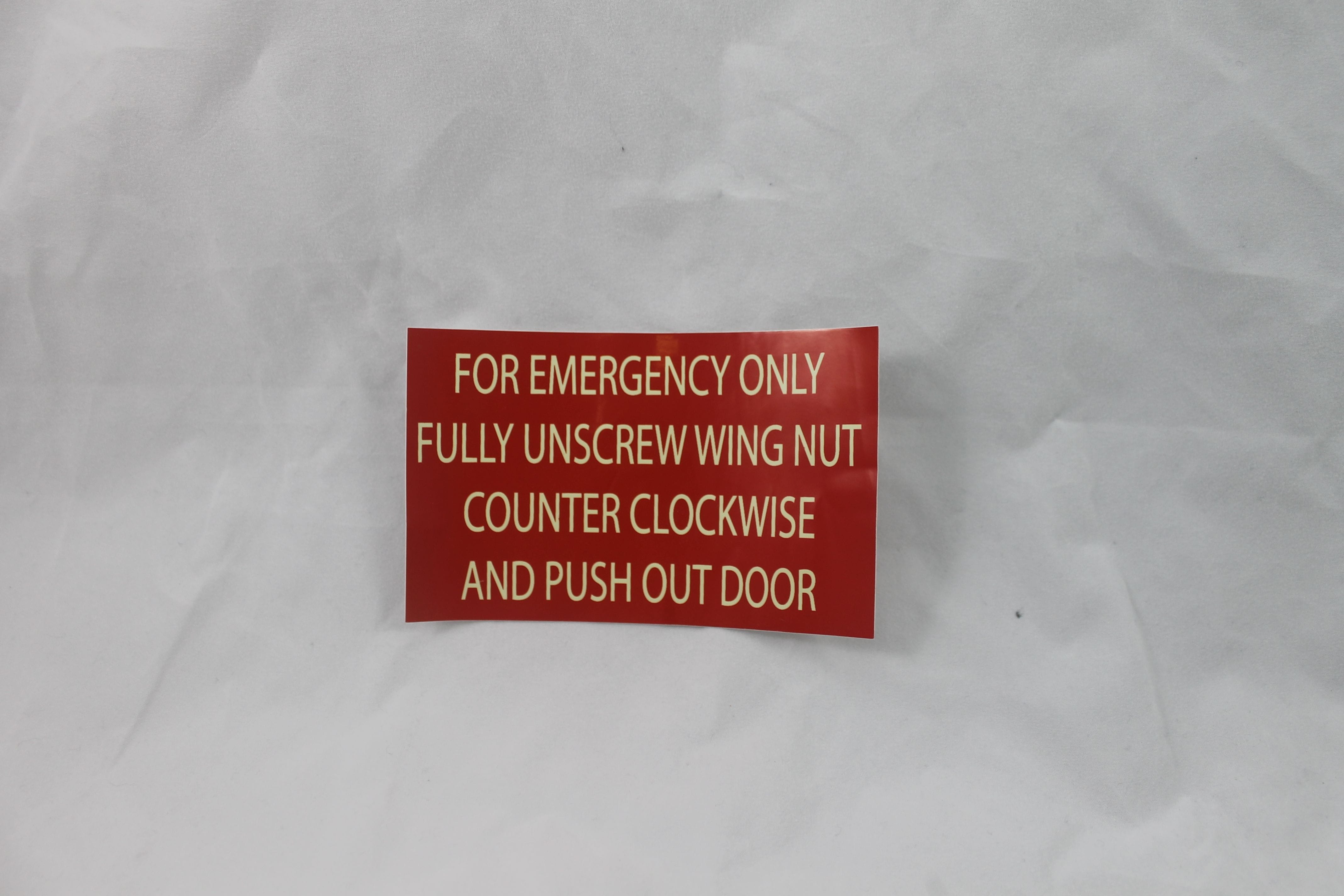 Fluorescent Emergency Sticker - Unscrew wing nut and push door out