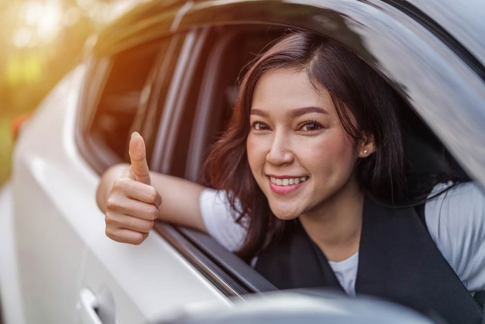 Woman Giving Thumbs Up While Inside A Car