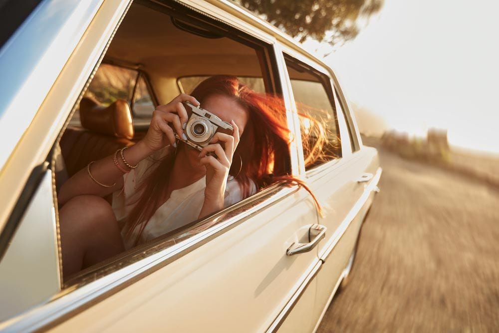 Woman Taking A Picture During Road Trip