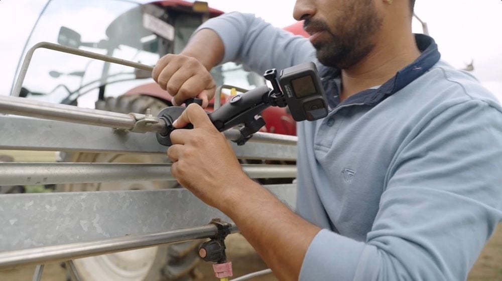 A GoPro being attached to a farm vehicle to capture footage of berries