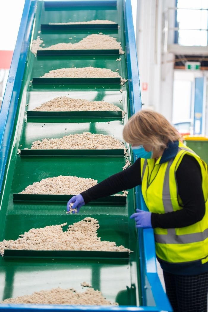 A worker at the cat litter conveyor.