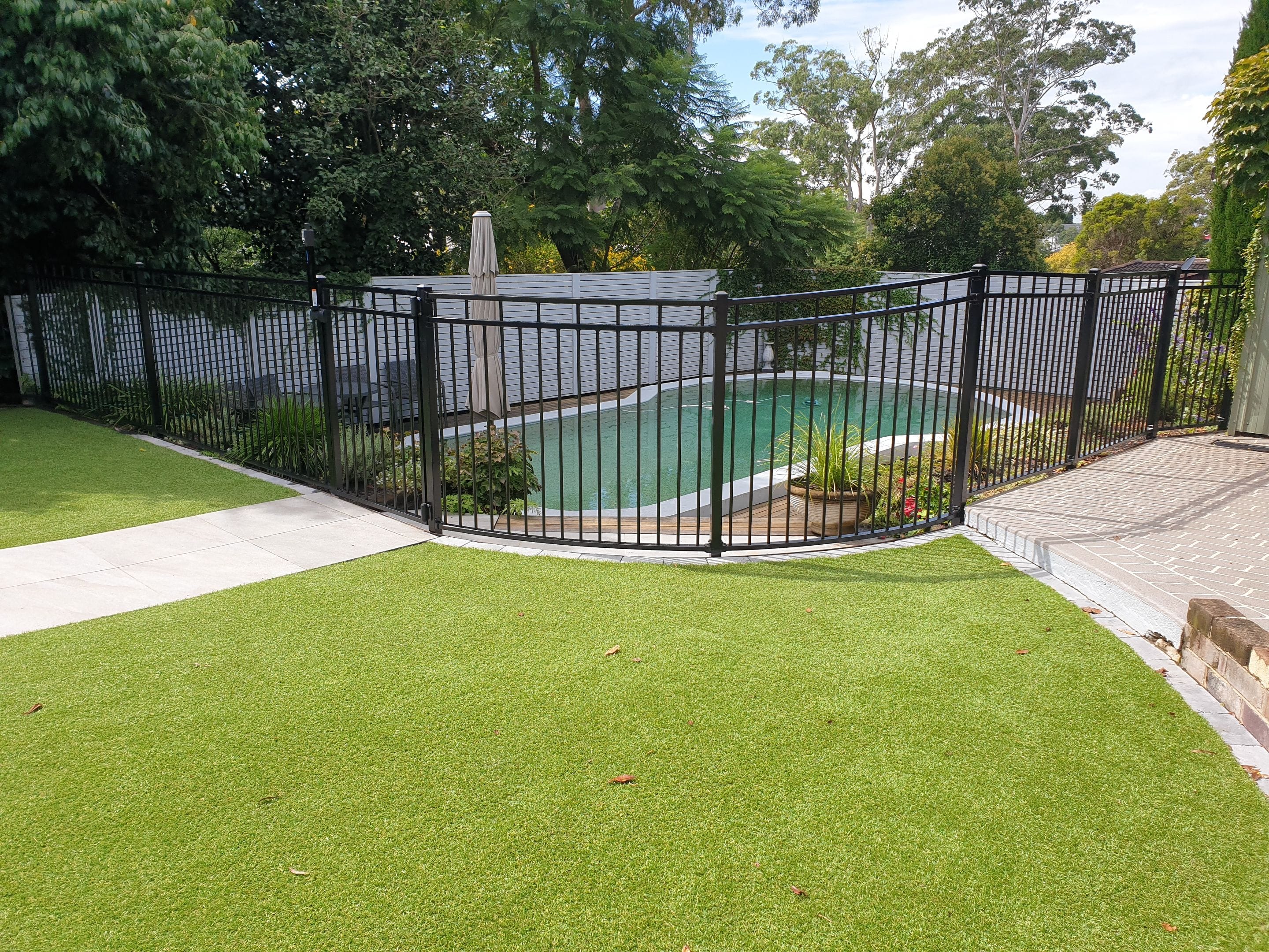 Curved raked black double top rail pool fence, Pennant Hills