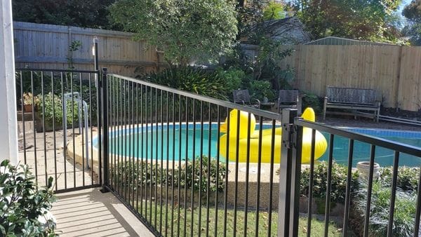 raked-black-tubular-pool-fence---timber-paling-boundary