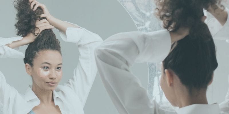 Woman looking at herself in the mirror. 