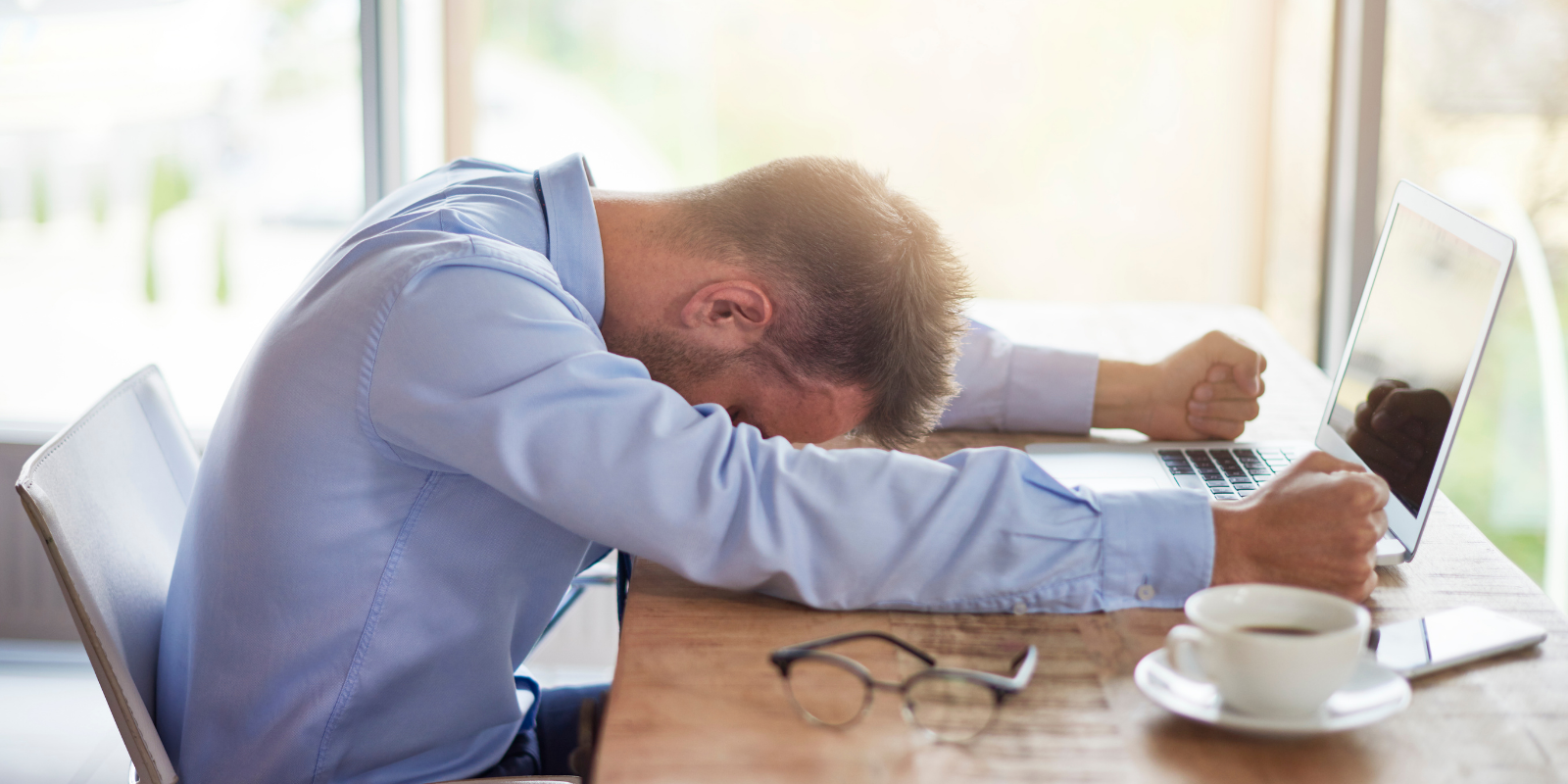Man showing stress with his head down on a desk