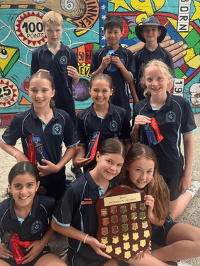 Celebrating Achievement in School Sport School sports team holding ribbons and shield celebrating achievement and participation