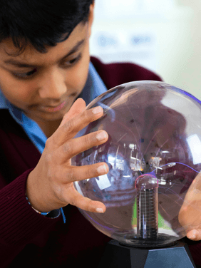 Exploring Science Through Hands-On Inquiry Student investigating a plasma globe during a hands-on science lesson in the STEAM lab