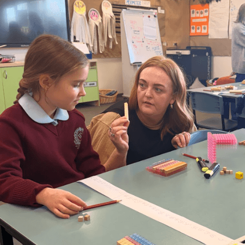 Teacher and student discussing mathematical thinking and problem-solving strategies during a classroom learning experience.
