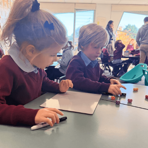 Students applying mathematical thinking and problem-solving skills through collaborative classroom learning activities.