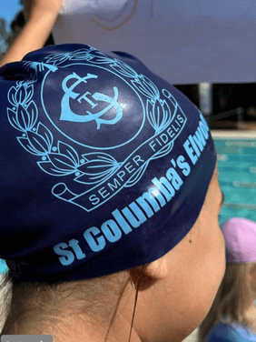 Building Confidence in Swimming and Water Safety Student wearing St Columba’s swim cap standing beside the pool during swimming program