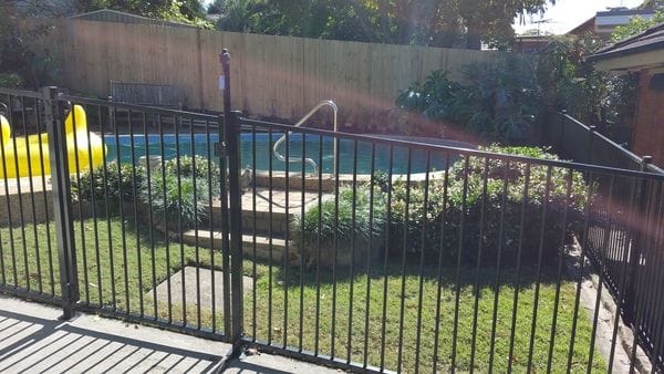 raked-black-tubular-pool-fence---timber-paling-boundary