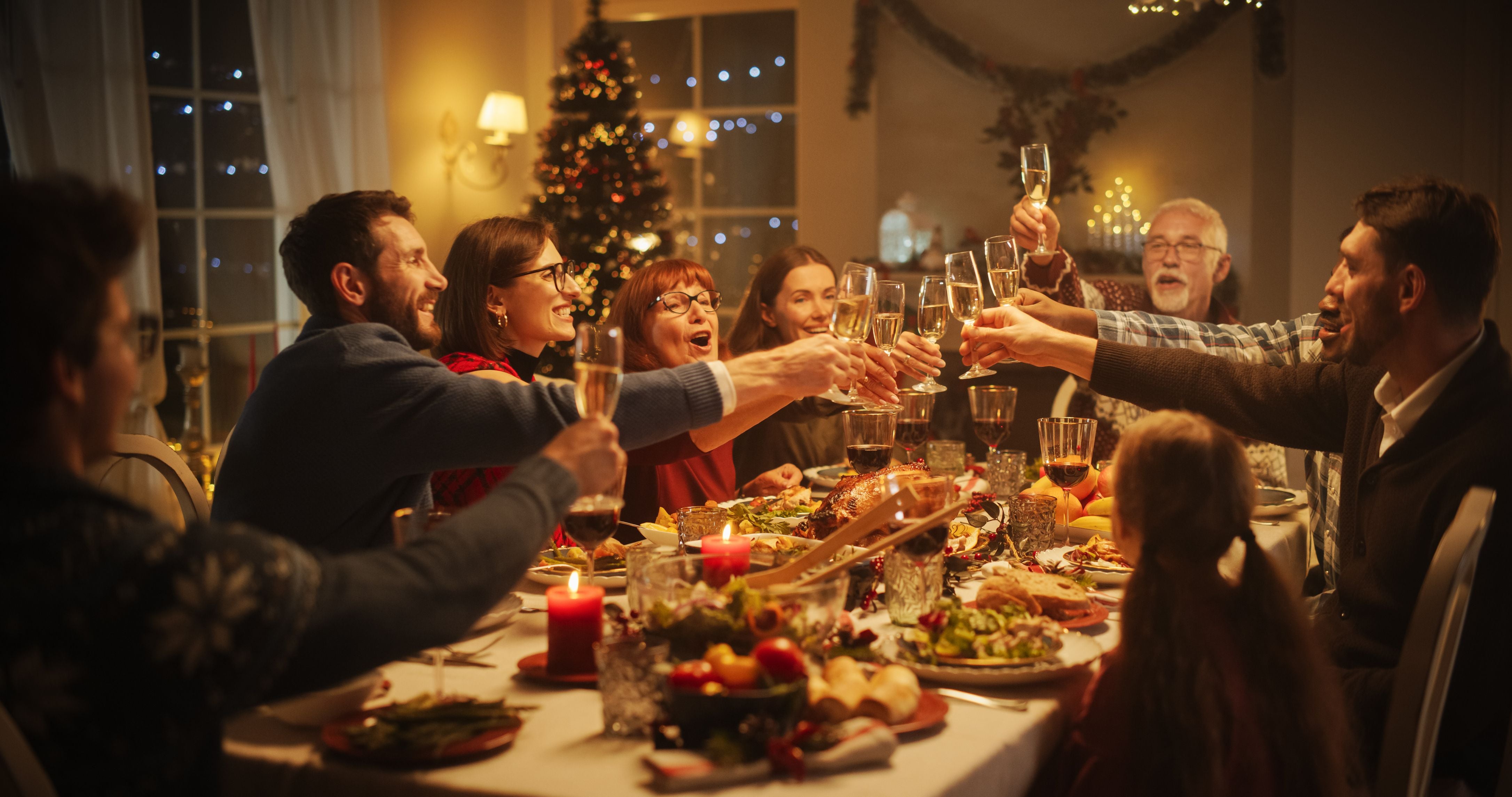 People gathered around a big dining room table celebrating the holidy with family and friends