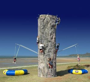 5 people rock climbing bungee wall set-up at the beach